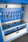 Panneau perforé avec outils suspendus et plan de travail