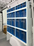 Paroi du fourgon aménagée avec des tiroirs transparents basculants de différentes tailles