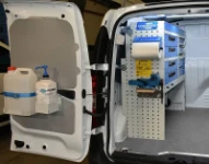 Rayonnage avec porte-étau, porte-rouleau et bloc tiroirs sur le côté gauche du Dokker