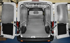 Un bel exemplaire de Ford Transit avec plancher en bois marbré et panneaux en aluminium strié