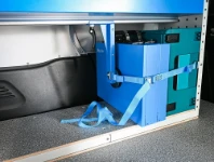 Valises arrimées avec sangles à boucle sur le plancher du fourgon